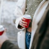 Crop couple drinking takeaway beverages on street