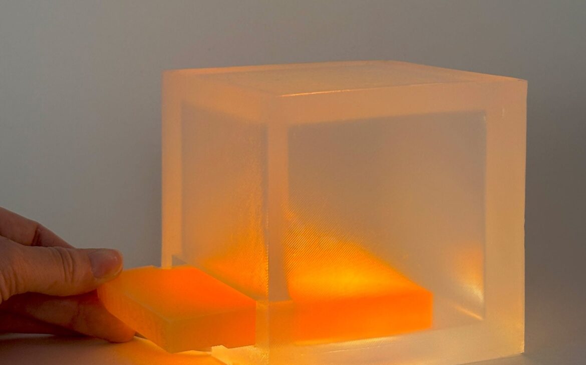 Slotting an amber silicone slide into the lamp. Source: Dezeen